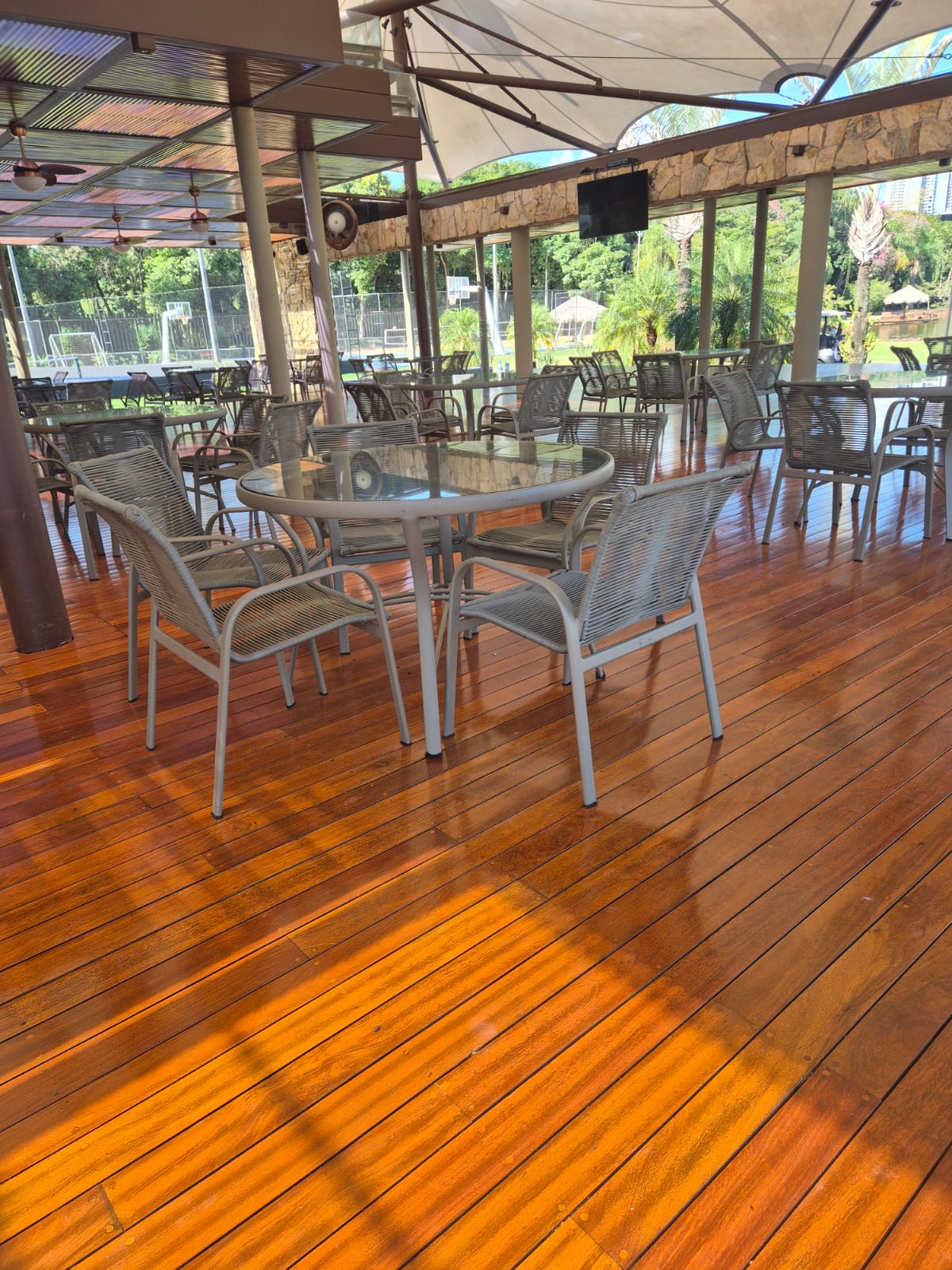 Deck de madeira em área de lazer com mesas
